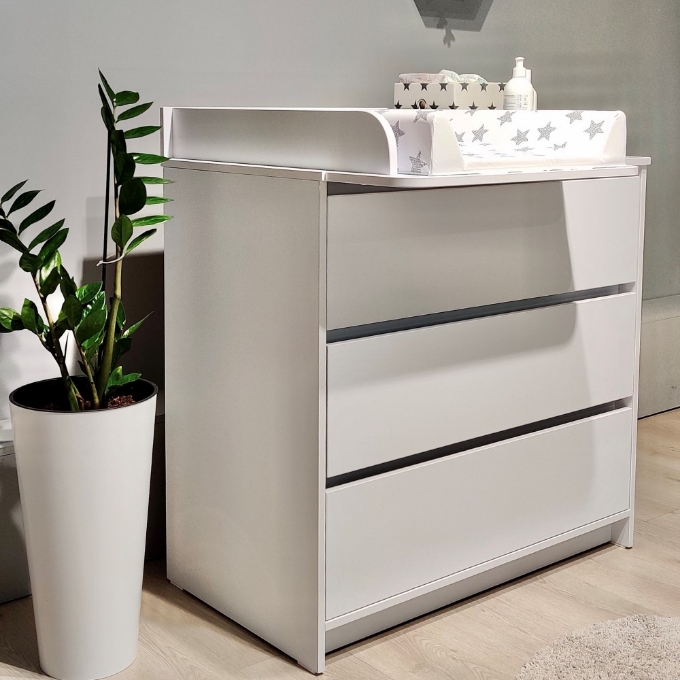 a white dresser with a potted plant in front of it
